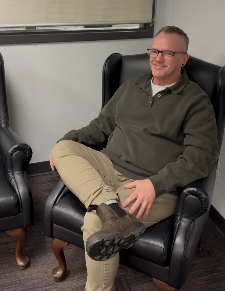 Dean Rasmussen, seated and smiling